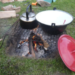 campfire and grill with kettle and large jam pan on top