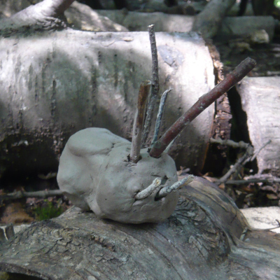 clay creature with small sticks as body features