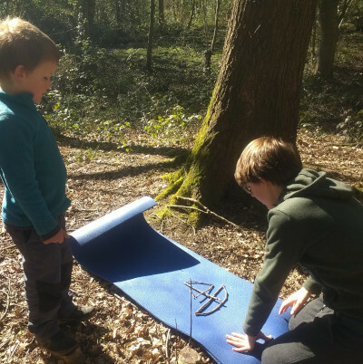 Two children making a boat shape out of sticks