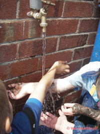 muddy hands outside an outside tap