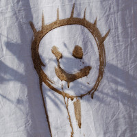 smiley face drawn in mud