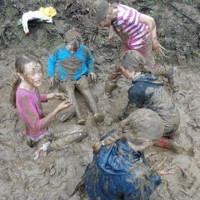 a gang of girls sitting in a mud puddle