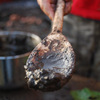 wooden spoon covered in mud