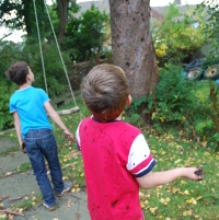 boys throwing mud at a tree