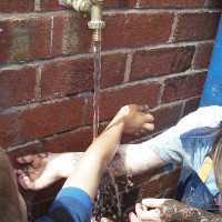 washing hands with an outdoor tap