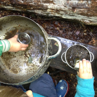children playing with a big muddy pot