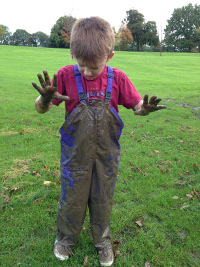 boy in very muddy dungarees